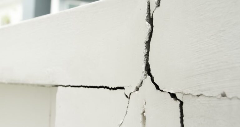 Cracks running through a painted concrete exterior wall on a Florida condominium building